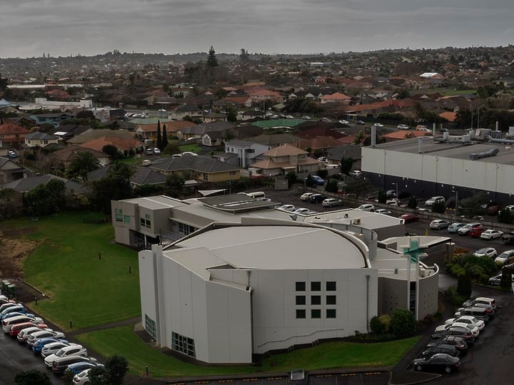 Aerial view of large church building with car parks in suburban setting