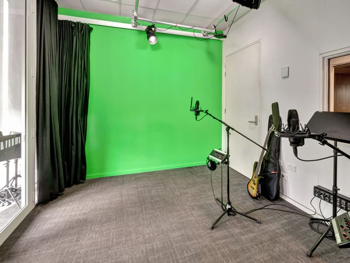 Recording studio room with green screen, microphones and guitar