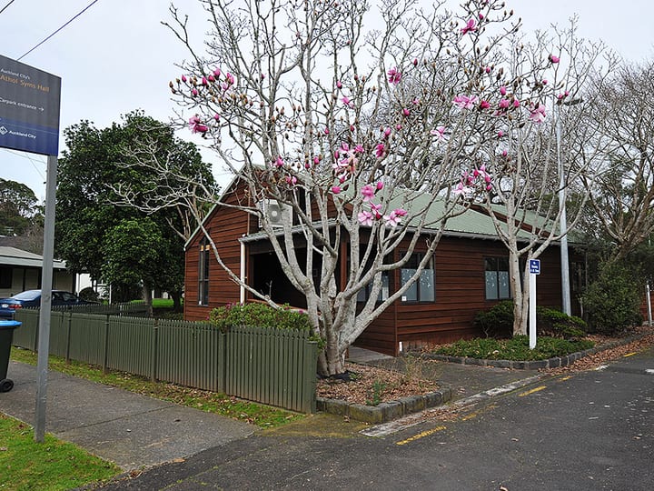 Weatherboard hall exterior with flowering tree in foreground