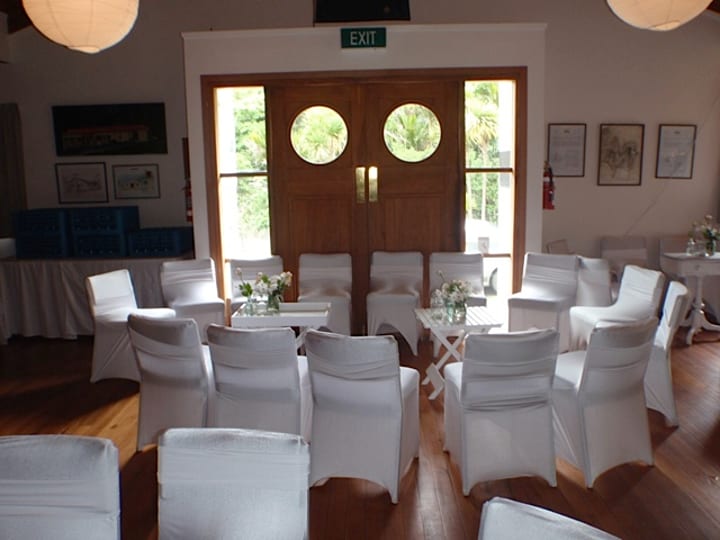 Hall set for a wedding with white chair covers and round porthole doors