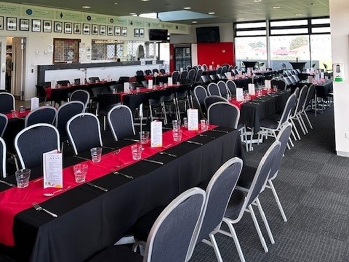 Function room with long tables set in black and red for a dining event