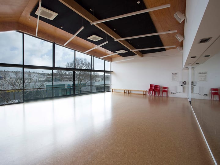 Studio with polished floor, wooden ceiling panels and full-height glazing