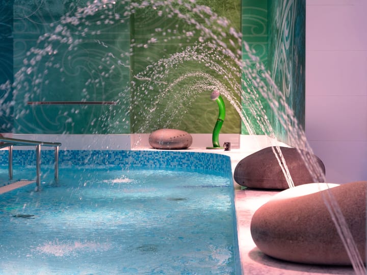 Indoor hydrotherapy pool with water jets and decorative rock features