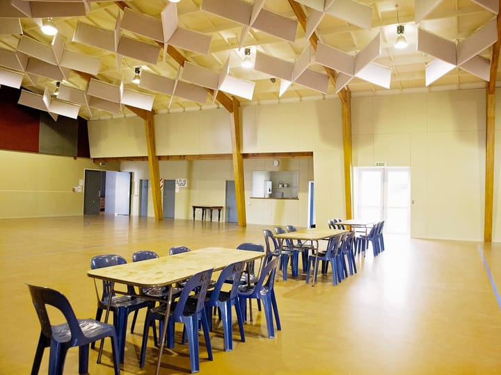 Large hall with trestle tables, chairs and timber-framed ceiling