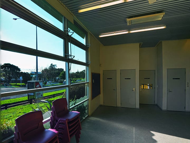 Foyer area with full-height glazed wall and stacked chairs