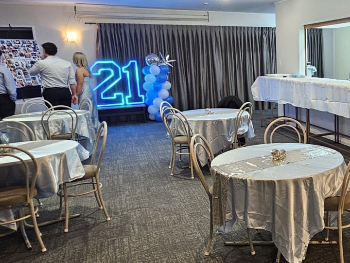 Function room dressed with balloons and round tables for a birthday celebration