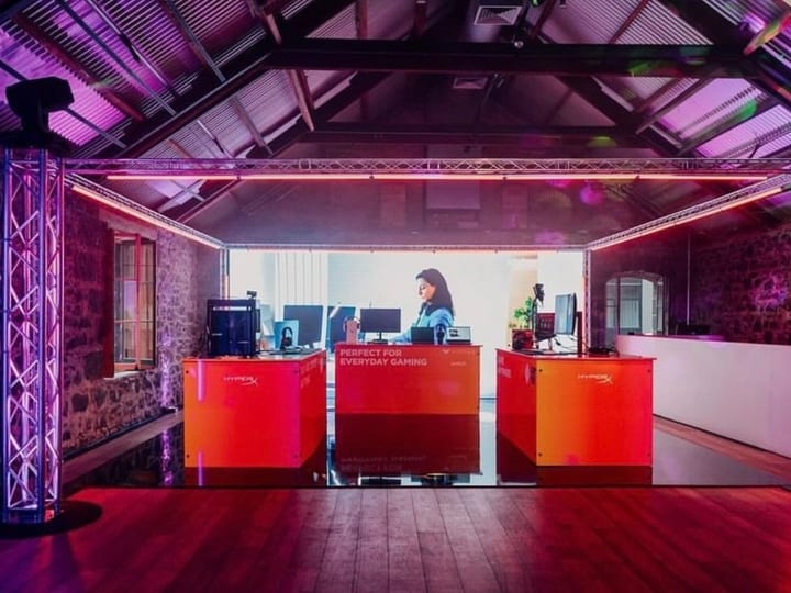 Stone-walled interior with exposed timber trusses and red uplighting, fitted with truss rigging and projector screen