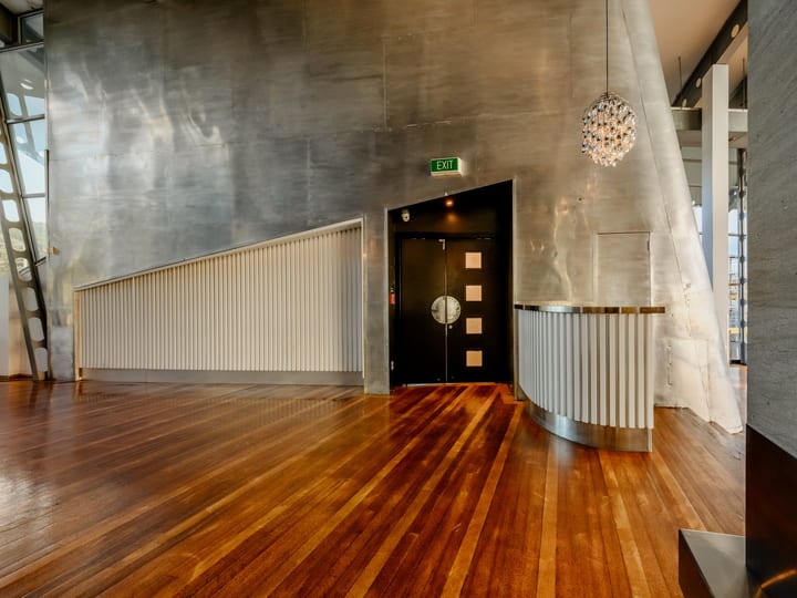 Industrial venue foyer with polished timber floor, metal walls and pendant light
