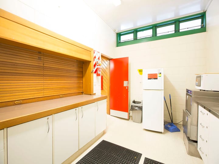 Kitchen servery counter with roller-shutter hatch and appliances