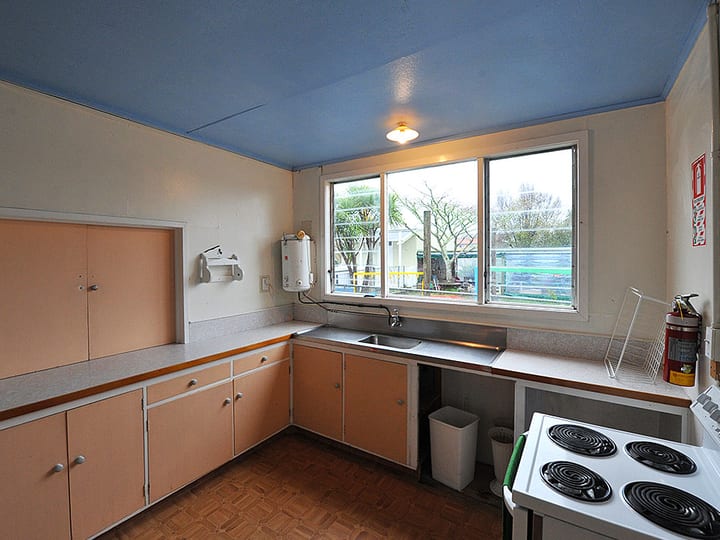 Dated kitchen with pastel laminate cabinets and electric stove