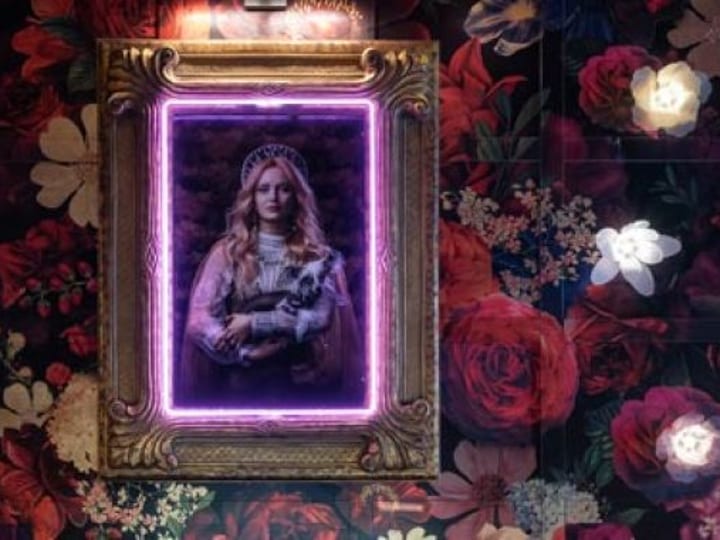 Ornate gold frame with neon pink border, floral wallpaper surround