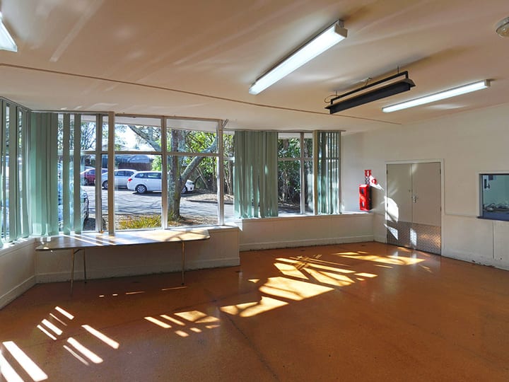 Plain hall room with orange vinyl floor, doors and small service windows