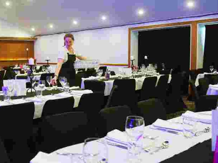 Conference room with theatre-style seating, projection screen and chandelier
