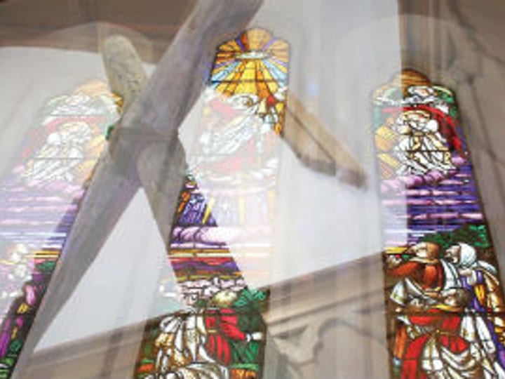 Church interior with stained glass windows and wooden cross