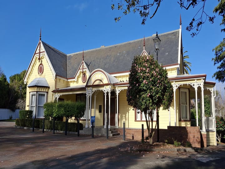 Victorian villa with yellow weatherboard and ornate gabled roofline