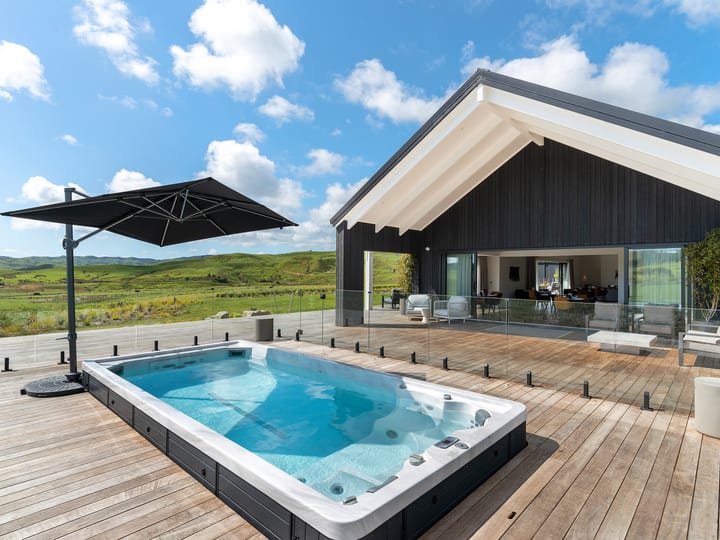 Timber deck with pool, outdoor furniture and rural hill views