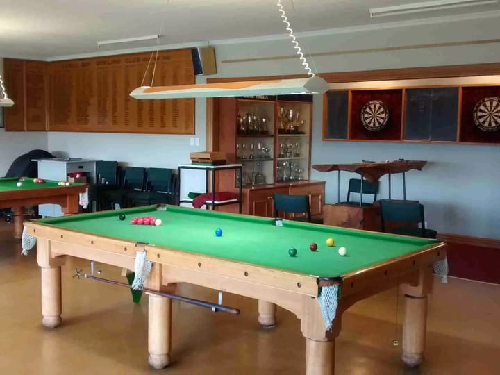 Games room with snooker tables, dartboards and trophy cabinet