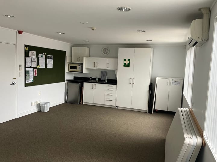 Small room with kitchenette, noticeboard, microwave and storage cabinets