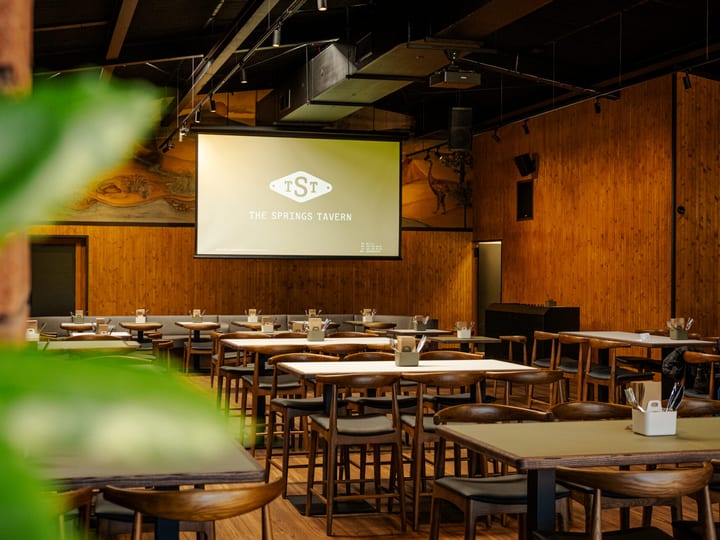 Tavern dining room with timber-lined walls, projection screen and set tables