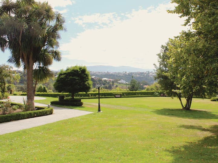 Manicured lawns and mature trees with views across the Dunedin hills