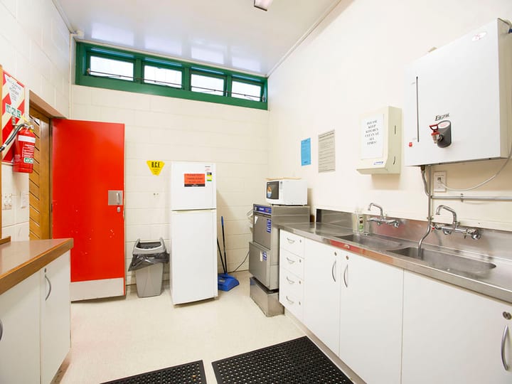 Utility kitchen with fridge, stainless sink, microwave, and dishwasher