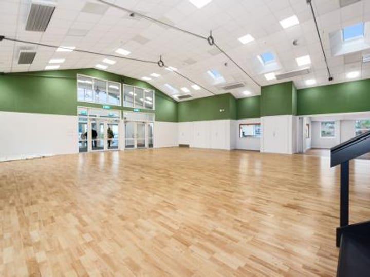 Large hall interior with green accent walls and timber floor