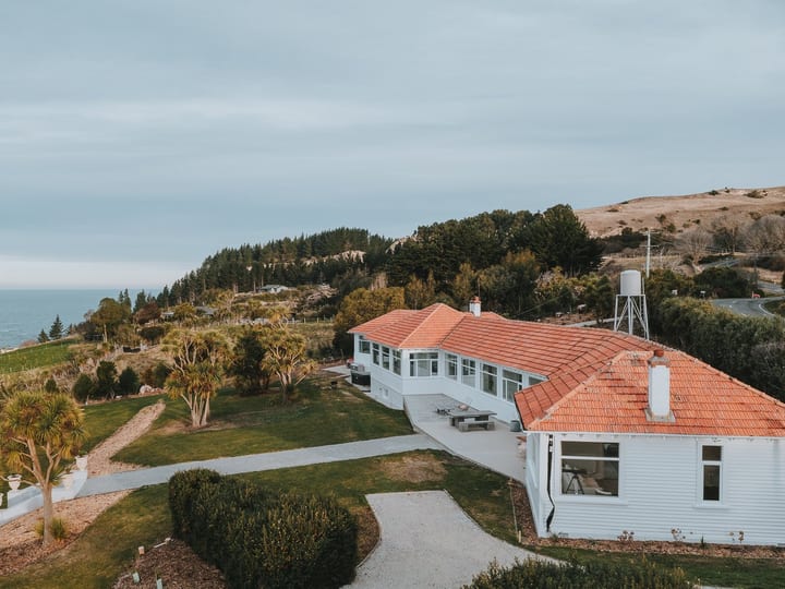Aerial view of white villa with terracotta roof on coastal hillside