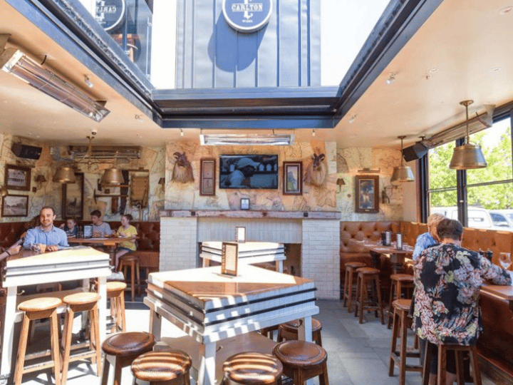 Semi-open bar area with retractable roof panels, fireplace, leather booths, high tables and stools