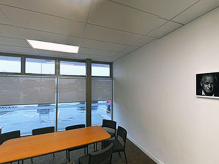 Small meeting room with timber table and portrait photo on wall