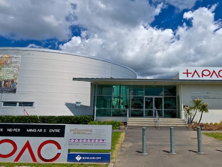 Performing arts centre exterior with curved facade and TAPAC signage under blue sky