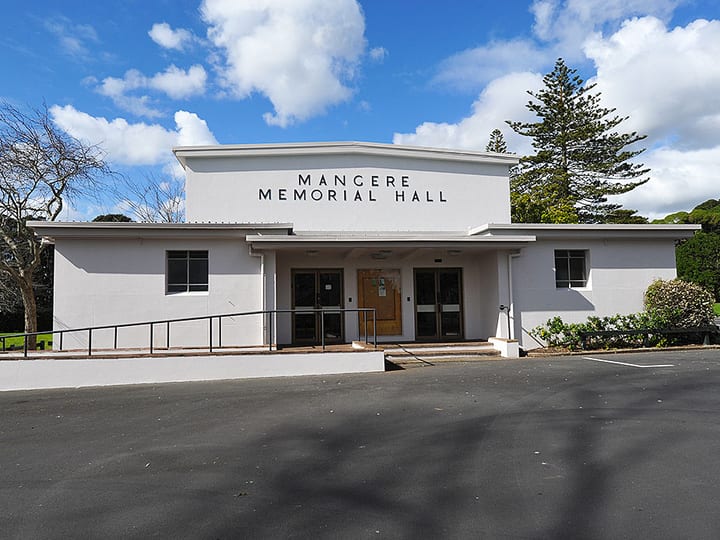White rendered memorial hall exterior with entry steps and signage