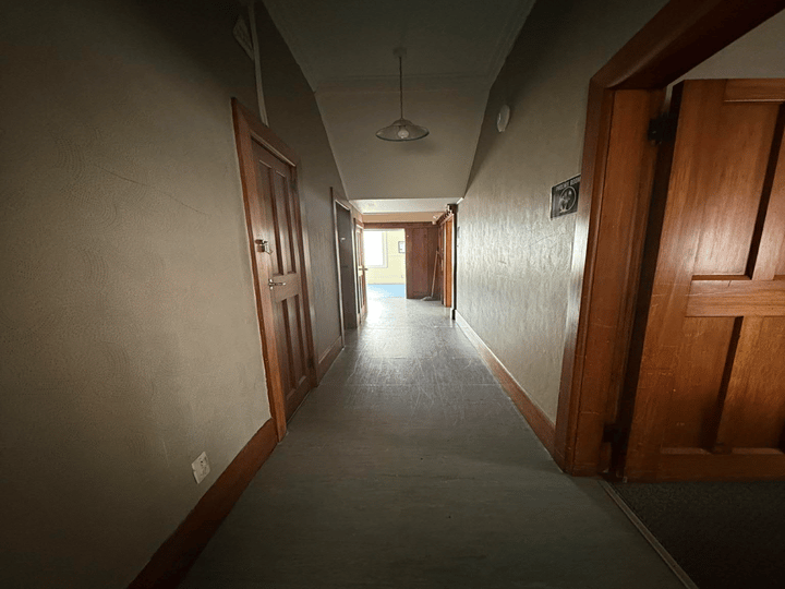 Small enclosed porch with couch, cushions and door to toilet and deck