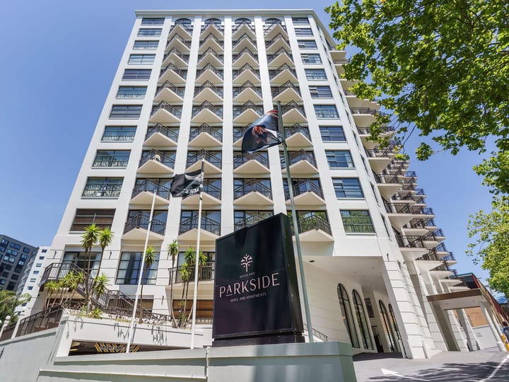 Tall multi-storey hotel building exterior with flags and signage