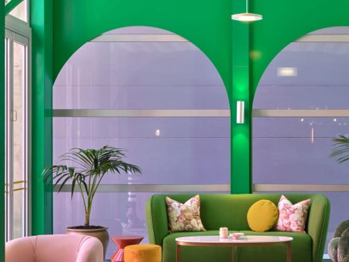 Vibrant green lounge area with arched alcoves, green sofas and colourful cushions