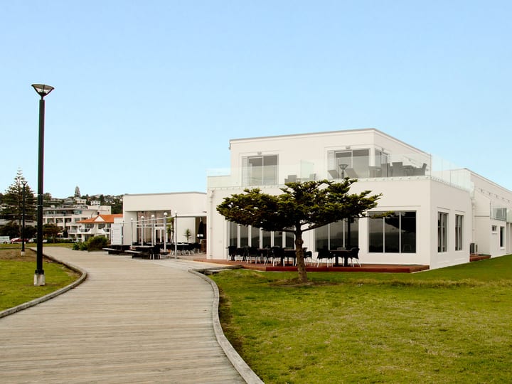 White hotel building exterior with lawn and boardwalk approach