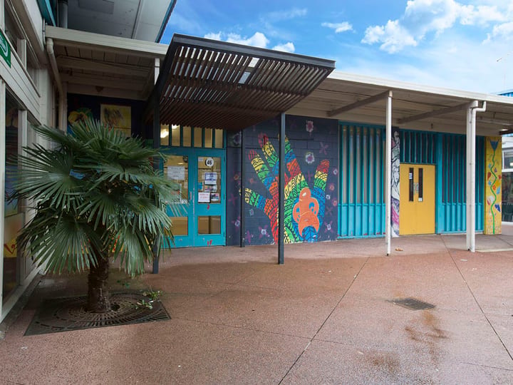 Low-rise building with colourful murals on exterior walls