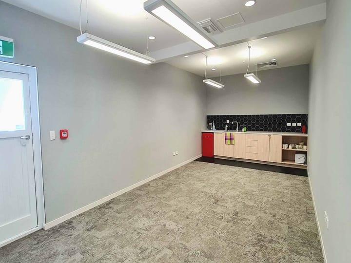 Small room with kitchenette bench, tiled splashback, and pendant lights