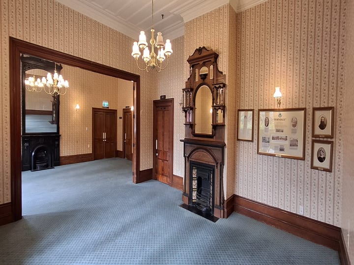 Victorian parlour with fireplace, ornate mirror overmantel and framed prints