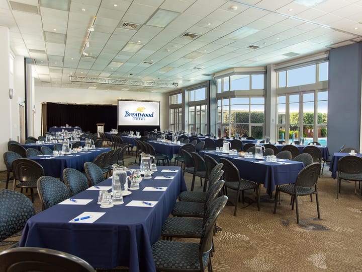 Conference room with round tables, projection screen and large windows