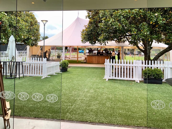 View through glass doors to marquee tent on lawn with trees