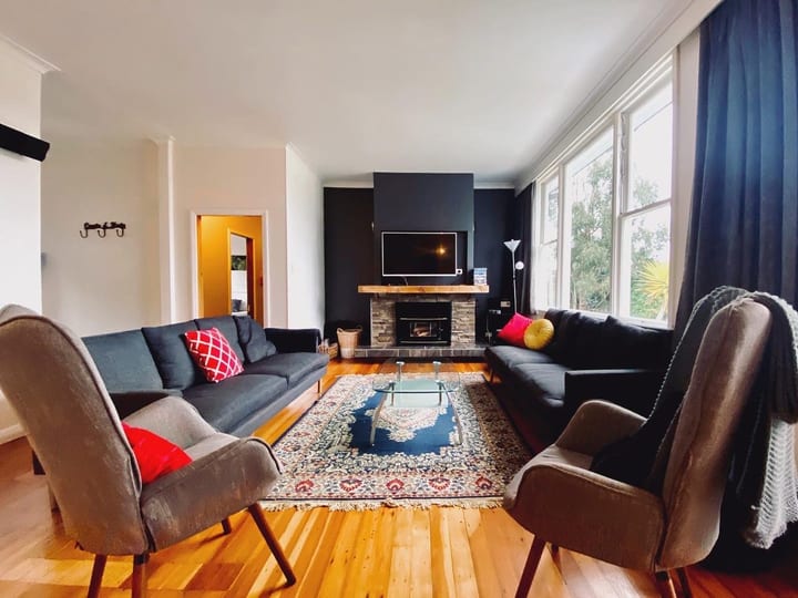 Lounge with sofas, armchairs, patterned rug and stone fireplace