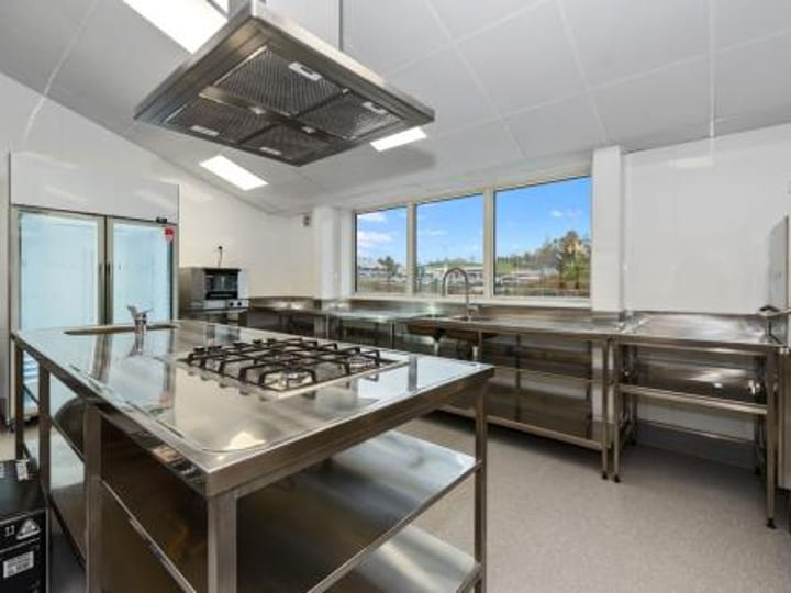 Commercial kitchen with stainless island bench and appliances