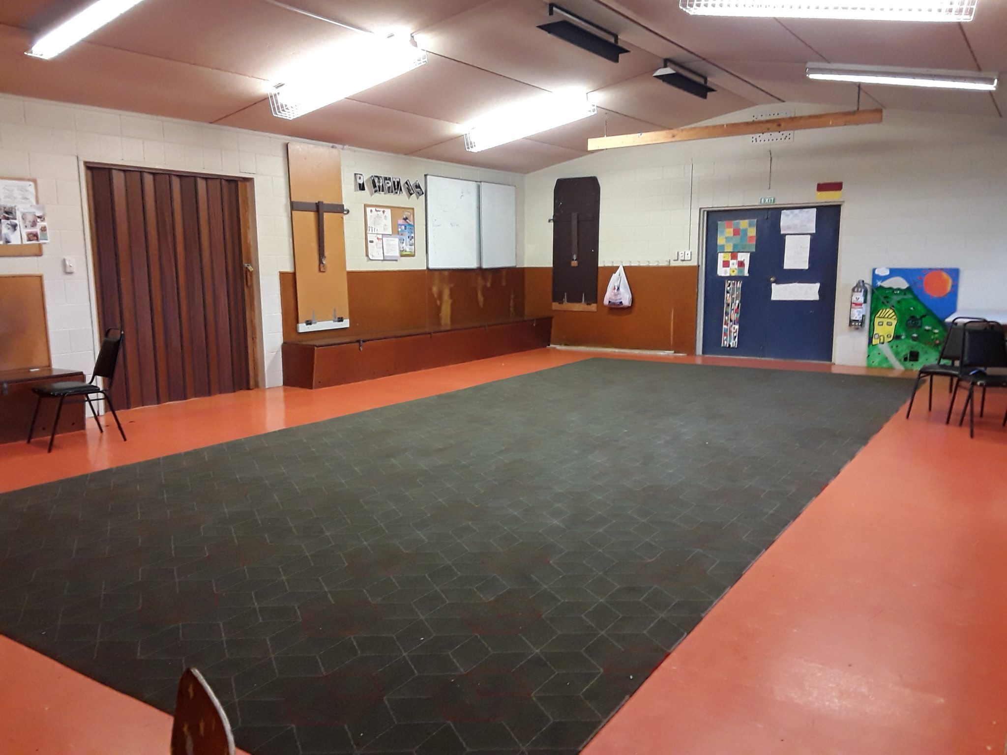 Plain hall interior with orange floor, brown wall panelling and carpet